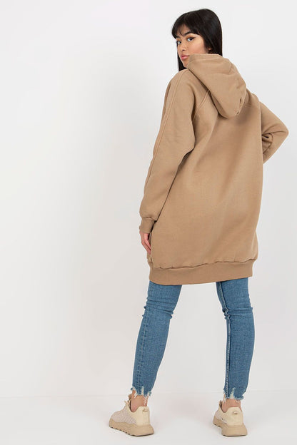 Damen langer Hoodie in Beige mit Kapuze, vom Model getragen in der Rückansicht.
